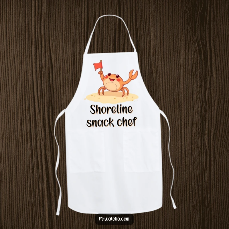 Funny crab apron showing a cheerful crab waving a small flag on a sandy beach, perfect for beach-themed cooking and baking.