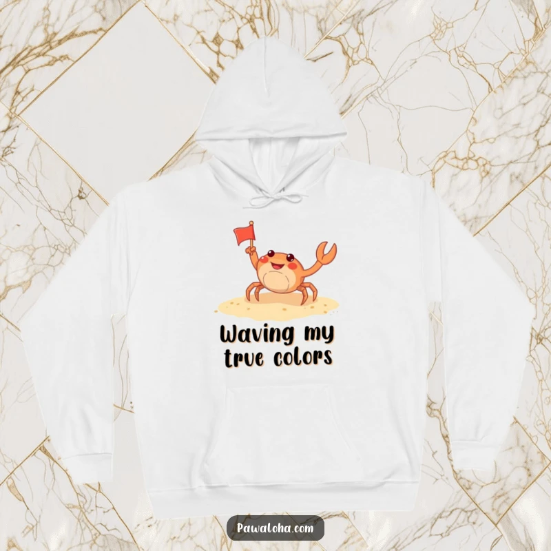 Funny crab hoodie depicting a cheerful crab waving a tiny flag on a sandy beach, perfect for cozy beach-themed relaxation.
