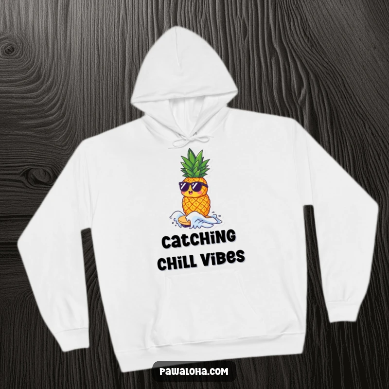 Funny hoodie with a small pineapple character wearing sunglasses, riding a tiny wave, designed for ultimate comfort and cool vibes.